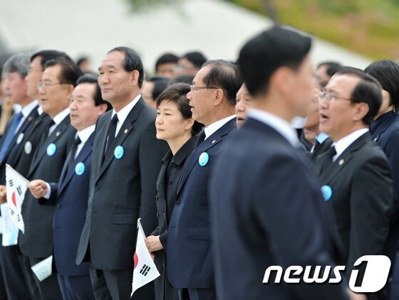 박근혜 대통령이 2013년 5월 18일 오전 광주 북구 운정동 5·18국립묘지에서 열린 5·18 민주화운동 33주년 기념식에 참석해 합창단이 '임을 위한 행진곡'을 합창하자 태극기를 들고 서있다.  2013.5.18/뉴스1