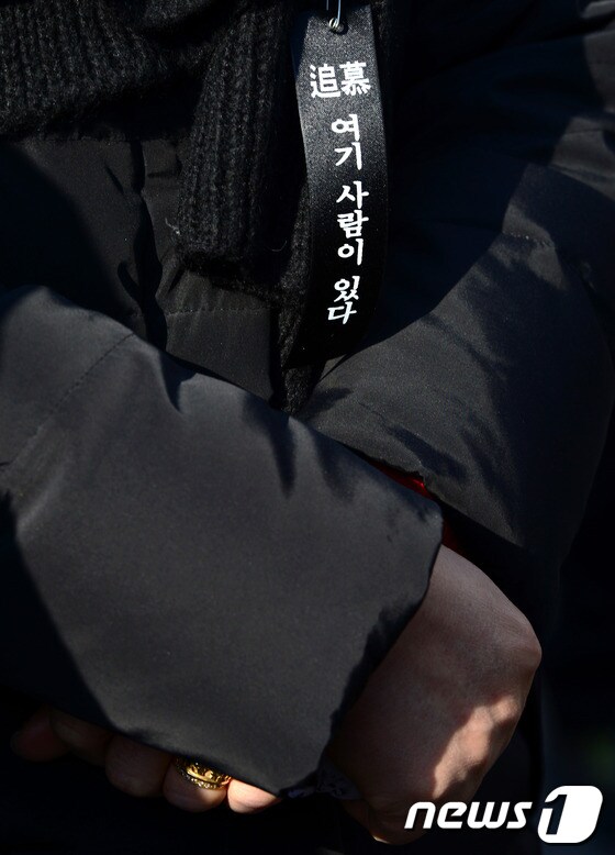 지난 2014년 1월 서울 용산 남일당 터에서 열린 '용산참사 5주기' 추모 집회에서 유가족들의 가슴에 '여기 사람이 있다'는 리본이 달려 있다. 2014.1.18/뉴스1