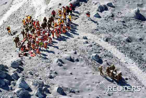 1일 구조대원들이 분화한 온타케 산 정상 인근에서 실종자 수색작업 도중 발견한 심폐정지자를 이송하고 있다.© 로이터=뉴스1