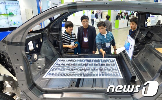 전기차 배터리 모형을 살펴보고 있는 관람객들. © News1 송은석 기자