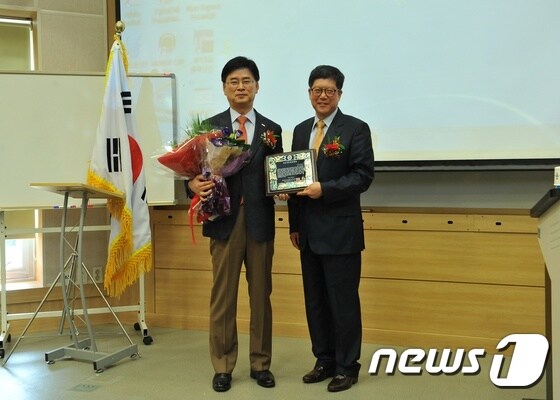 조폐공사 김화동 사장(좌로부터 6번째)이 지속가능경영대상을 수상한 후 학회의 학술위원 및 조직의원들과 함께 포즈를 취하고 있다. © News1