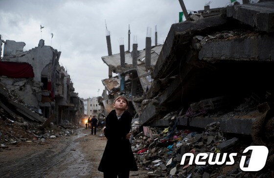 팔레스타인 소년이 이스라엘과 하마스의 전쟁으로 인해 폐허가 된 마을에 서있다. © AFP=뉴스1