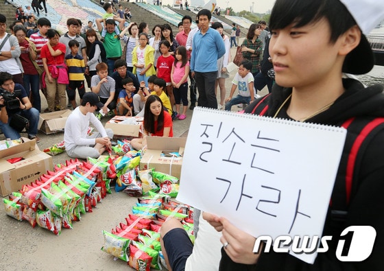 제과업계의 과자 과대포장에 항의하는 대학생들이 28일 오후 서울 잠실한강공원 선착장에서 과자 180개를 이어 붙여 ´과자 뗏목´을 만들고 있다. © News1