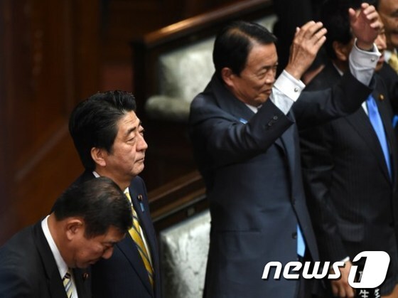 아소 다로(麻生太郞) 일본 부총리가 만세를 외치고 있다. 왼편에는 아베 총리가 단상을 지켜보고 있다. © AFP=News1
