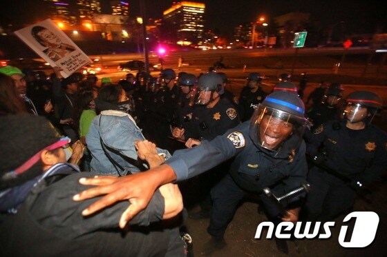 미국 캘리포니아주 로스앤젤레스에서도 미주리주 대배심의 평결에 분노한 주민들의 시위가 열렸다. 사진은 도로를 점거한 시위대를 경찰이 해산하는 모습. © AFP=뉴스1