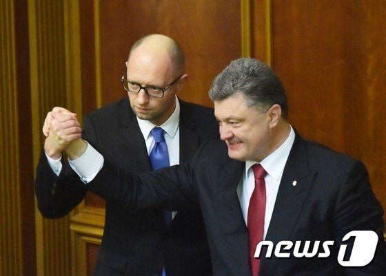 27일(현지시간) 우크라이나 총리로 선출된 아르세니 야체뉵 총리(왼쪽)가 페트로 포로셴코 대통령과 손을 잡고 있다. © AFP=뉴스1