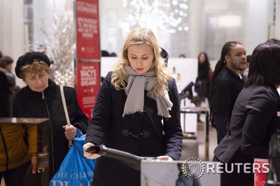 한 여성이 추수감사절인 27일(현지시간) 뉴욕의 메이시스 백화점에서 부츠를 꼼꼼하게 들여다보고 있다.© 로이터=뉴스1