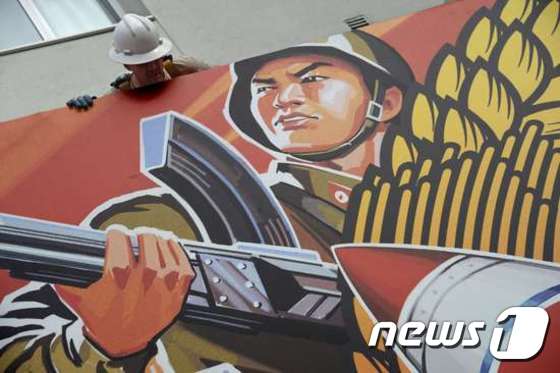미국 로스앤젤레스의 노동자들이 18일(현지시간) 할리우드 극장에 설치된, 북한지도자 김정은 암살을 소재로 한 코미디 영화 