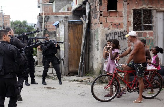 브라질 월드컵 준비의 일환으로 브라질 당국은 리우데자네이루의 빈민가를 철거했다. 올 3월 철거를 위해 파견된 경찰들이 빈민가 아이들에게 총을 겨누고 있다. © 로이터=뉴스1 © News1