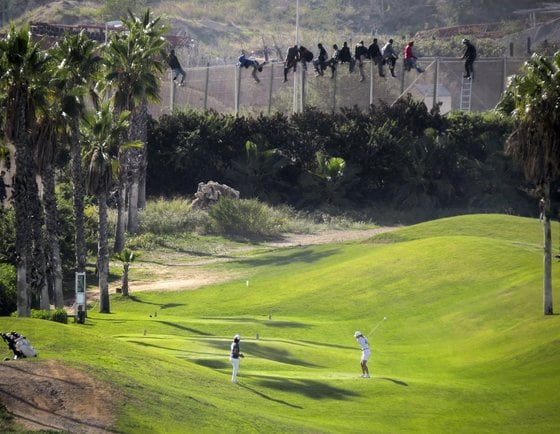 지난 10월 사람들이 평화롭게 골프를 치는 가운데 한편에서는 모로코 난민들이 모로코 북동부에 위치한 스페인 영토 멜리야로 넘어가기 위해 밀입국을 시도하고 있다. © 로이터=뉴스1 © News1