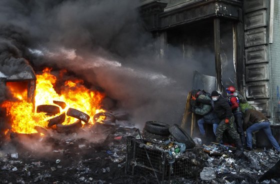 지난 1월 우크라이나 시위대가 친 러시아 세력의 물 공격을 막아내고 있다. 친 러시아계인 빅토르 야누코비치 전 대통령이 시위를 금지하는 법안을 통과시키자 친 서방 세력의 항의는 더욱 격렬해졌다. 로이터=뉴스1 © News1