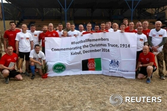 German and British troops pose for a photo after a football match to commemorating the Christmas Truce of 1914, at the ISAF Headquarters in Kabul