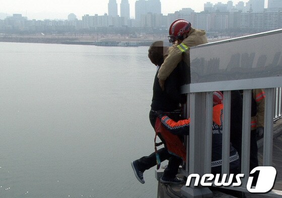 서울 마포대교 전망대에서 자살을 시도한 사고가 발생해 구조대원들이 남성을 구조하고 있다(영등포소방서 제공)./뉴스1