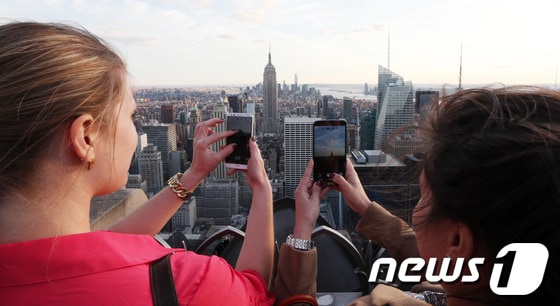 지난해 4월 말 미국 뉴욕 맨해튼 록펠러센터 GE 빌딩 톱 오브 더 록 전망대에서 뉴요커들이 LG 스마트폰 G2와 G플랙스로 뉴욕 도심을 담고 있다.(한국언론진흥재단 후원) 2014.6.12/뉴스1 © News1