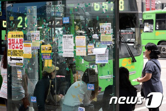 8일 오전 서울 영등포동 한 버스정류장에 각종 불법 전단지와 전단지를 붙이는데 사용한 접착테이프들이 나붙어 있다. 2014.7.8/뉴스1 © News1