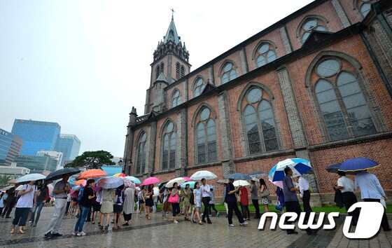 프란치스코 교황의 방한 마지막 공식 일정을 하루 앞둔 17일 오전 서울 중구 명동성당에서 미사를 보려는 신자들이 우산을 쓰고 줄을 서고 있다. 2014.8.17/뉴스1 © News1 송은석 기자