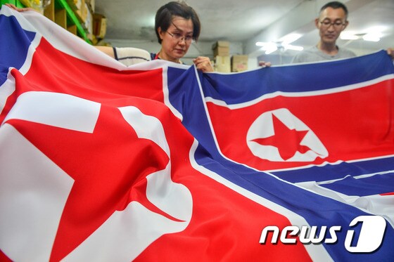지난달 19일 서울의 한 국기 제작 업체에서 직원들이 인천 아시안게임에 사용될 북한 인공기를 검수하고 있다. 2014.8.19/뉴스1 © News1 송은석 기자