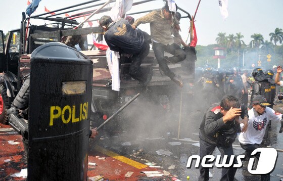 21일(현지시간) 인도네시아 경찰이 헌법재판소 인근에 운집한 프라보워 후보 지지자들에게 최루탄을 발사하고 있다.© AFP=뉴스1