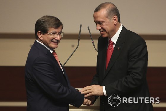 21일(현지시간) 터키 앙카라에서 열린 정의개발당(AKP) 집행위원회 회의에서 레제프 타이이프 에르도안 총리(오른쪽)가 차기 총리로 지명한 아흐메트 다부토글루 외무장관의 손을 잡고 있다.© 로이터=뉴스1