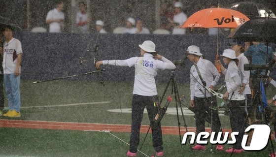 한국 양궁대표팀이 지난해 8월 26일 서울 목동야구장에서 열린 2014 한국야쿠르트 세븐 프로야구 넥센 히어로즈와 기아 타이거즈의 경기에 앞서 폭우 속에서도 적응훈련을 하고 있다. /뉴스1 © News1 양동욱 기자