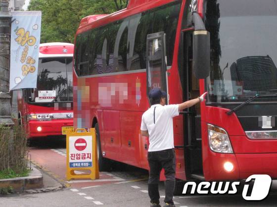 6일 경복궁 주차장 앞에서 주차 유도원이 자리가 없다며 관광버스의 진입을 막고 있다. © News1