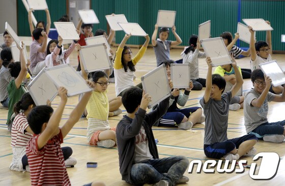 서울 성북초등학교 6학년 어린이들이 18일 학교 체육관에서 열린 학교폭력 예방을 위한 퀴즈 골든벨대회에서 답을 들고 있다. 2014.9.18/뉴스1 © News1 안은나 기자