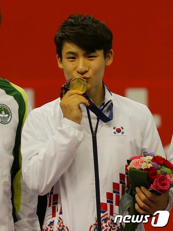 한국 남자 우슈의 기대주 이하성이 2014 인천 아시안 게임에서 한국에 첫 금메달을 안겼다. 이하성이 시상대에 올라 금메달에 입맞추고 있다. 2014.9.20/뉴스1 © News1 박지혜 기자