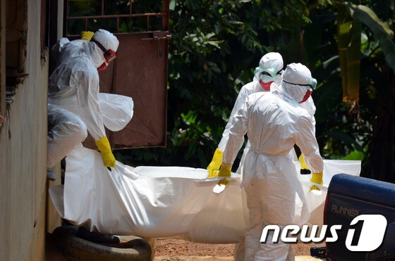 국제적십자 직원들이 에볼라 감염으로 사망한 생후 18개월 된 라이베리아 어린이의 시신을 수습하고 있다.© AFP=뉴스1