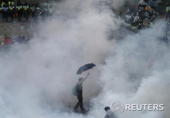 28일 홍콩에서 한 시민이 경찰이 살포한 최루가스 속에서 ´우산혁명´의 상징인 우산을 들고 시위를 독려하고 있다. © 로이터=뉴스1