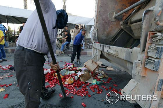이슬람국가(IS)가 직원으로 고용한 라카 주민들이 유통기한이 지나거나 부패한 식료품들을 폐기하고 있다.© 로이터=뉴스1