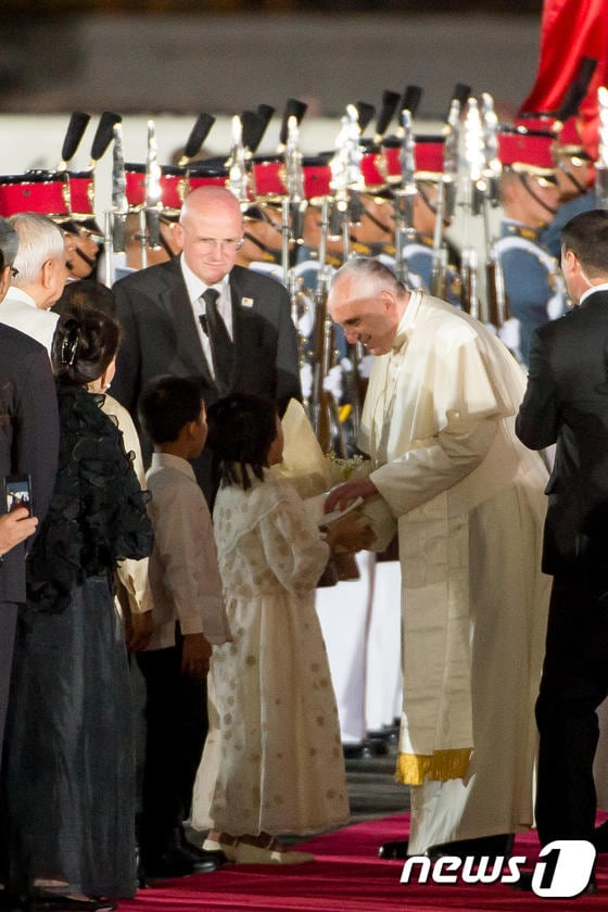 15일(현지시간) 필리핀에 도착한 프란치스코 교황이 아이들에게 꽃다발 선물을 받고 있다.©AFP=News1