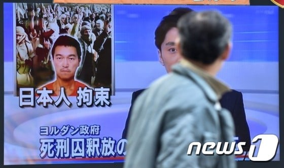 IS에 일본인이 억류돼 있다는 뉴스를 거리를 거리를 지나는 일본 시민이 지켜보고 있다 © AFP=뉴스1