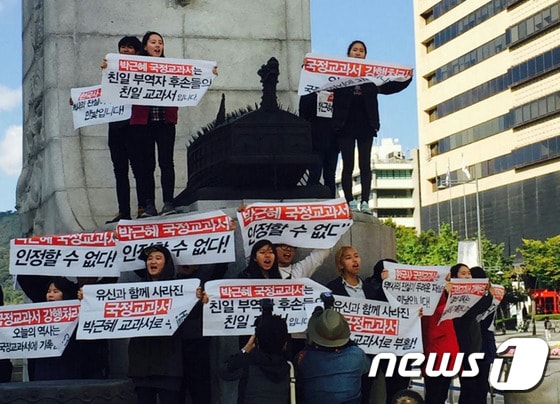 2015년 10월12일 서울 광화문 광장 이순신 동상 위에서 한국사 교과서 국정화에 반대하는 대학생들이 기습 시위를 벌이고 있다. 2015.10.12/뉴스1
