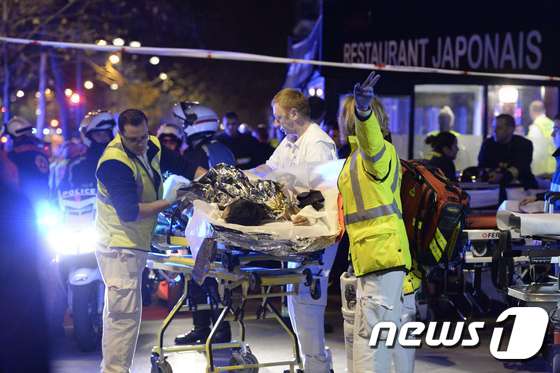 바타클랑 콘서트홀에서 발생한 테러 공격으로 부상한 피해자가 구급대원의 도움을 받고 있다.© AFP=뉴스1
