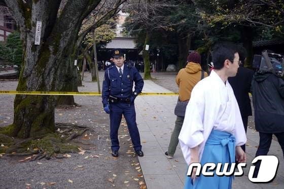 한 경찰관이 23일 오전 일본 도쿄(東京) 구단기타(九段北)의 야스쿠니(靖国) 신사 내 사고 현장에서 경비를 서고 있다. © AFP=뉴스1