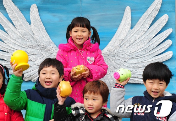 전북 전주시 노송동주민센터 앞 '천사의 날개'에서 저금통을 들고 서 있는 어린이들. /뉴스1