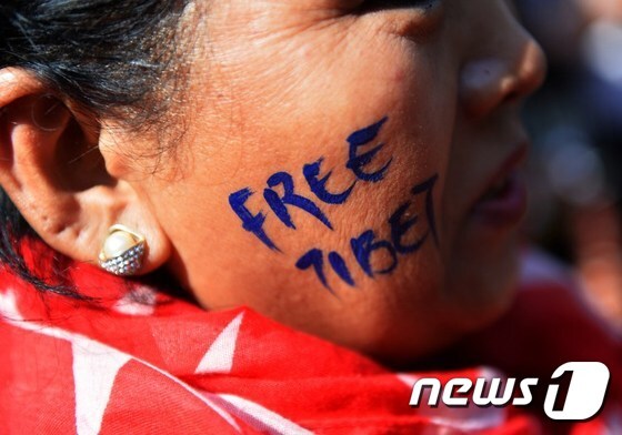 지난 10일(현지시간) 인도 뉴델리에서 열린 티베트 분리독립 시위에 참여한 한 시위대원의 뺨에 