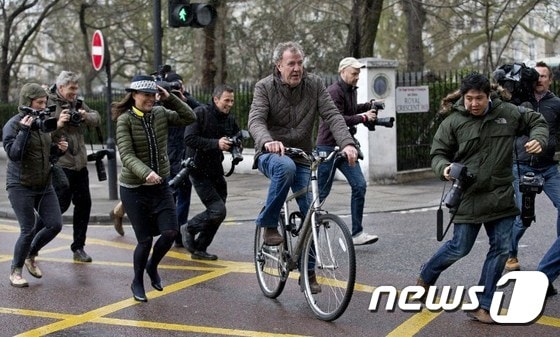 클락슨이 자전거를 타고 집을 나서자 취재진들이 몰려들고 있다. © AFP=뉴스1