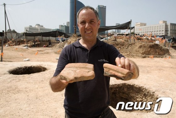 디에고 바르칸 고고학자가 이번에 발굴된 맥주 항아리 파편을 들어보이고 있다. © AFP=뉴스1
