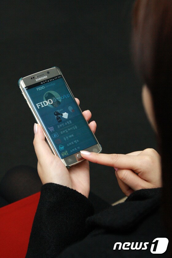 고객이 삼성전자의 최신 스마트폰 '갤럭시S6 엣지'를 이용해 FIDO 기반의 지문인식 솔루션을 체험하고 있다(사진제공 삼성SDS) © News1