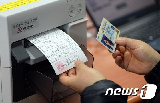 4·29 재·보궐 선거 사전투표가 실시된 지난 24일 서울 관악구 난향동주민센터에 마련된 투표소에서 선거사무원이 투표용지를 발급하고 있다. 2015.4.24/뉴스1 © News1 신웅수 기자