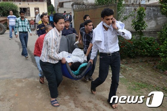 네팔 카트만두 주민들이 25일(현지시간) 발생한 리히터규모 7.9 강진으로 인해 다친 사람들을 이송하고 있다.© AFP=뉴스1