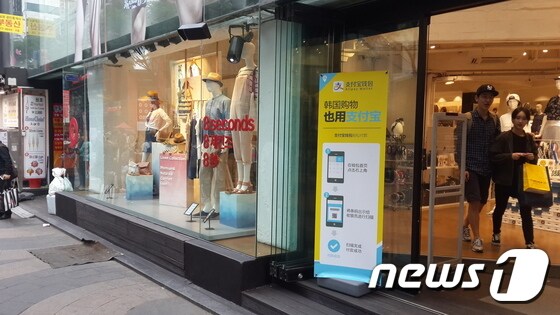 13일 서울 명동의 한 의류 매장 앞에 알리페이로 결제하는 방법을 설명하는 입간판이 서있다. 이 매장은 알리페이 전용 결제 창구를 운용해 중국 관광객의 편의성을 높이고 있었다.© News1