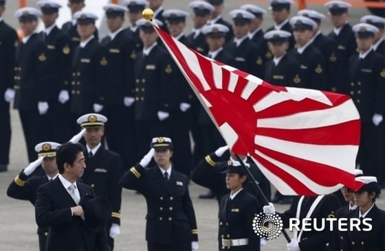 욱일승천기를 든 해상자위대 대원들로부터 경례를 받고 있는 아베 신조 일본 총리. 로이터=News1