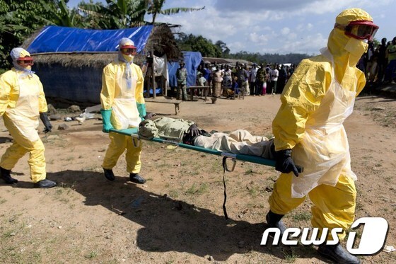 기니 보건당국 직원들이 에볼라 바이러스 감염자를 들 것에 실어 이송하고 있다. © AFP=뉴스1