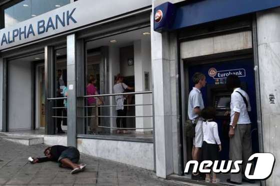 그리스 국민들이 현금인출기(ATM)에서 예금을 인출액하고 있다. 2015.7.6/뉴스1 © AFP=뉴스1