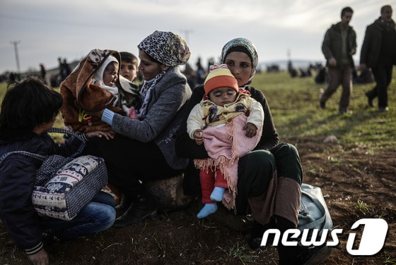 시리아의 쿠르드족 여성들이 터키 국경지역인 수루크에서 아이들과 함께 앉아 있다. © AFP=News1