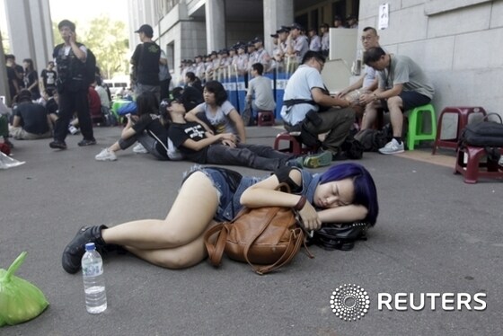 A student sleeps on the ground during a protest at the entrance to the Ministry of Education in Taipei