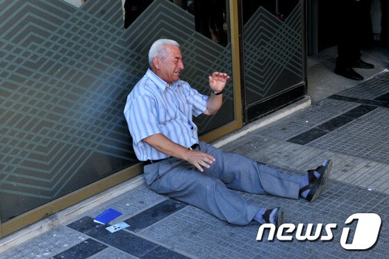 그리스 제2의 도시 테살로니키의 은퇴한 연금수령자 기오르고스 차치포시아디스(77)가 3일(현지시간) 현금인출기 앞에서 울음을 터뜨렸다. © AFP=뉴스1
