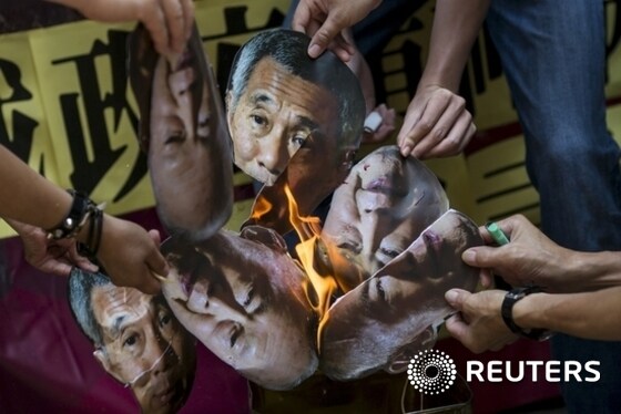 Protesters burn pictures of Singapore